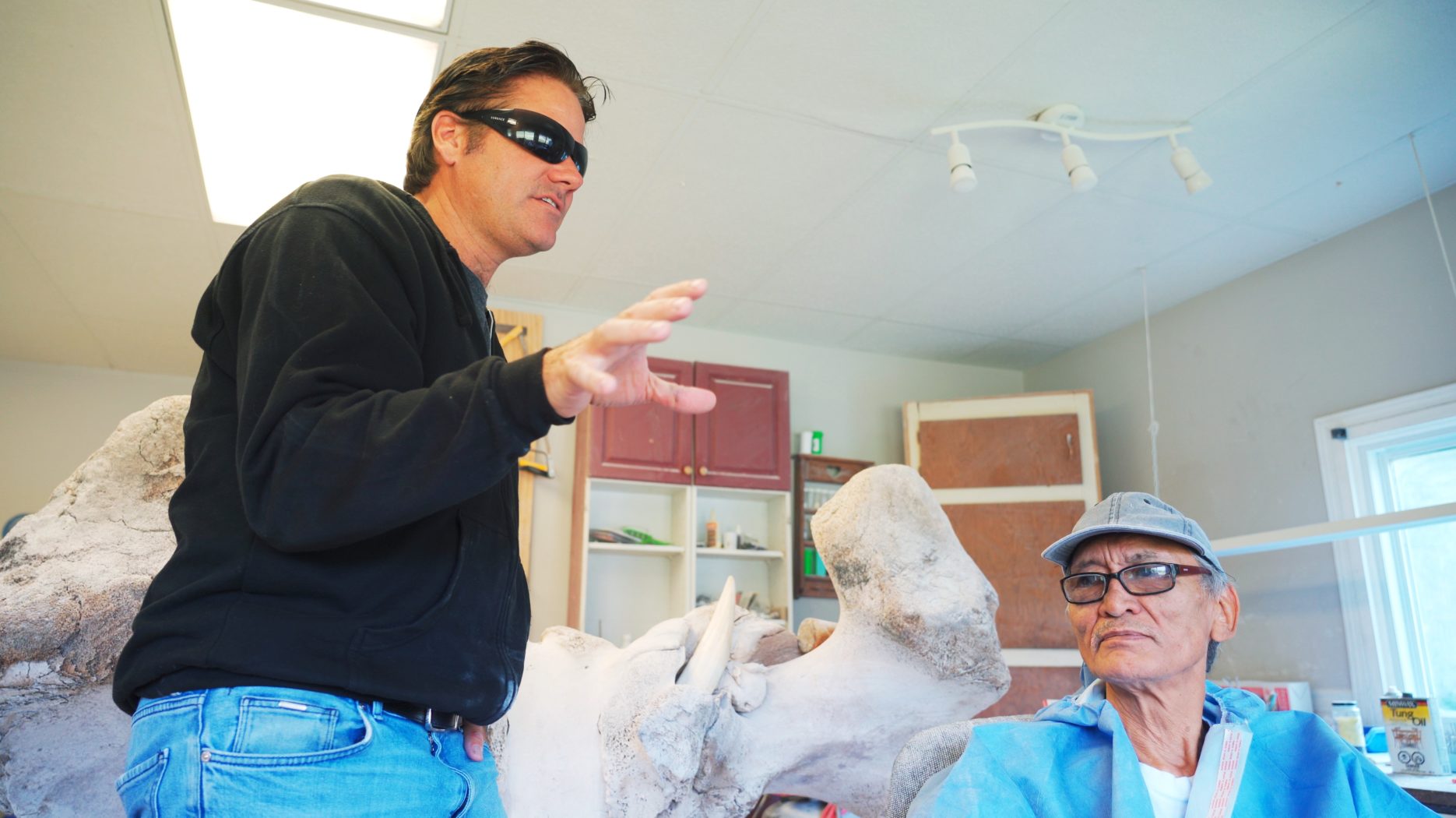 Man with sunglasses next to Inuit Artist